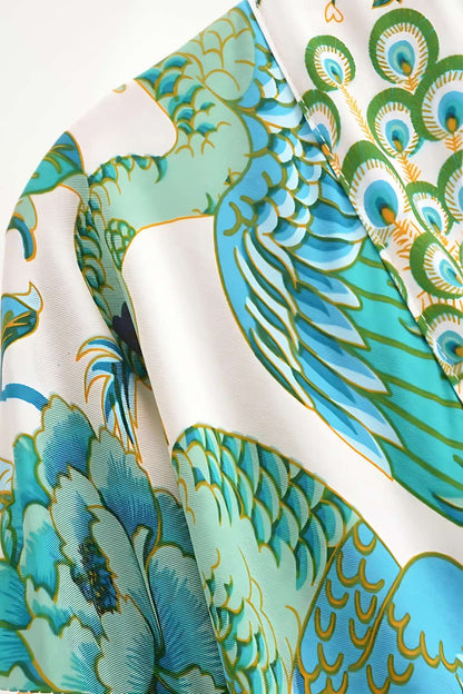 Détails d'un kimono court japonais aux motifs de plumes et fleurs dans des teintes de bleu et vert