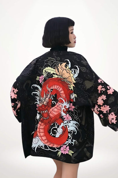 Femme portant un kimono noir avec un dragon rouge et des motifs floraux colorés, se tenant de profil