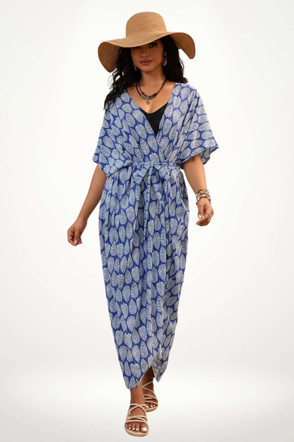 Femme portant un kimono bleu à motifs de feuilles, avec un chapeau large et des sandales, sur fond blanc