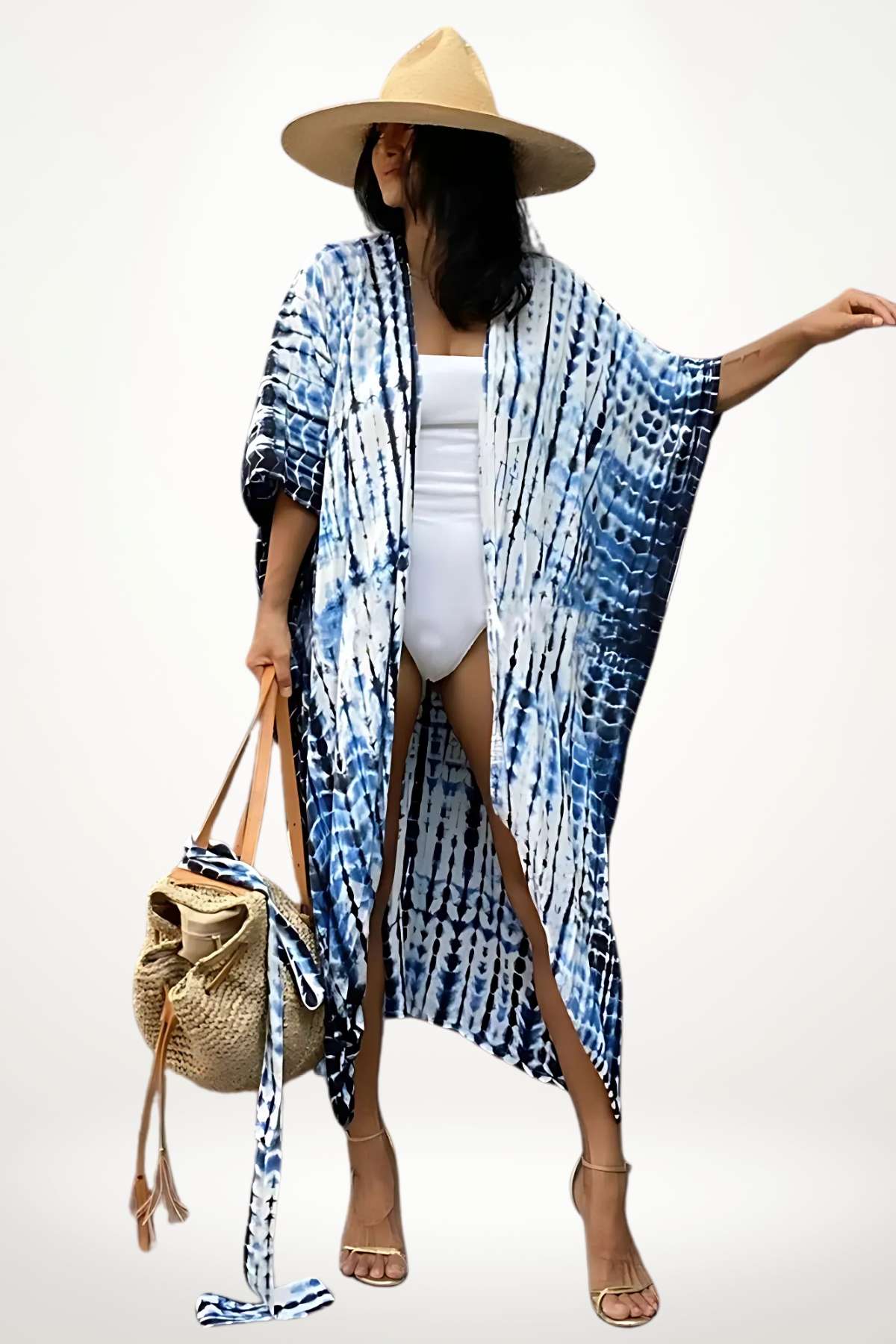 Femme portant un kimono de plage bleu et blanc, avec un chapeau de paille et un sac en osier