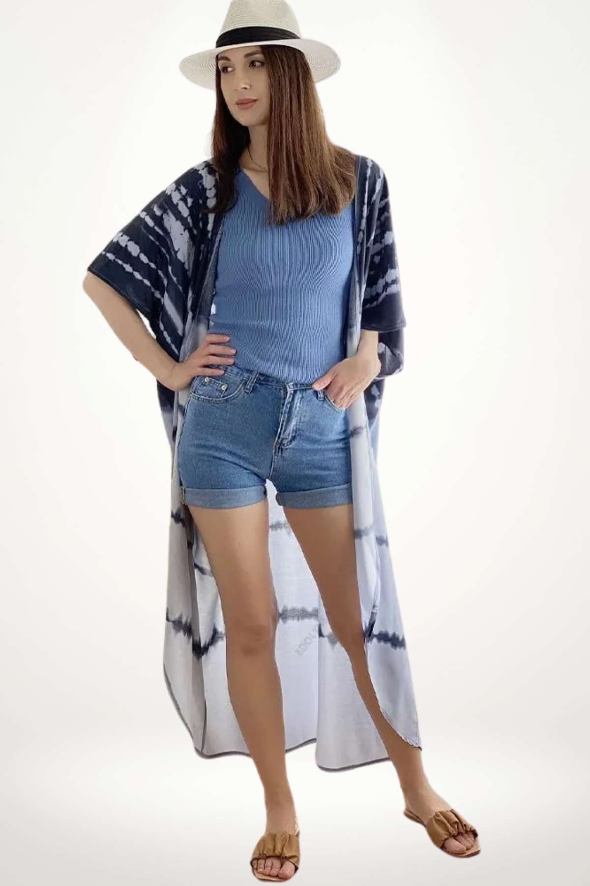 Femme portant un kimono léger à motifs tie-dye bleu, avec un haut bleu et un short en denim, dans un