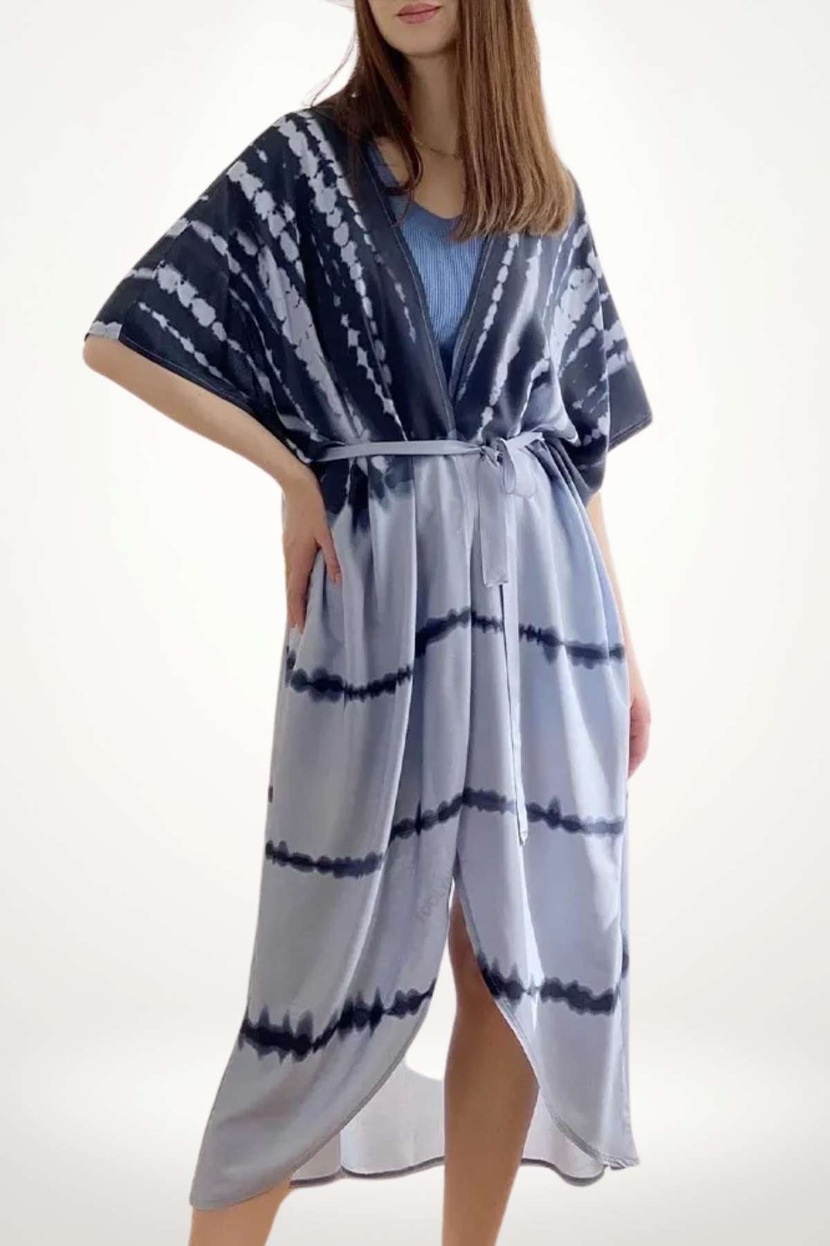 Kimono léger en dégradé bleu et blanc, avec un motif tie-dye, drapé élégamment sur une silhouette féminine