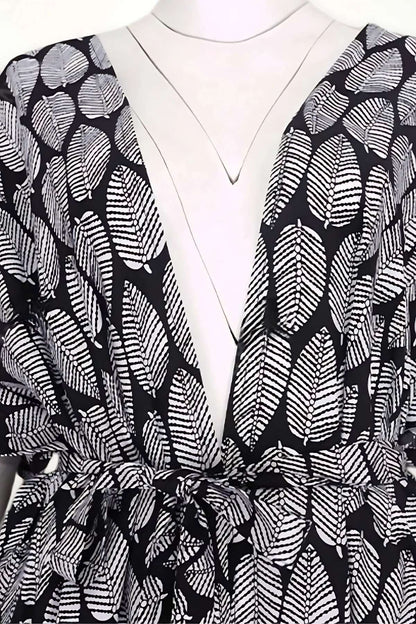 Kimono léger en tissu noir avec motifs de feuilles blanches, ceinturé à la taille, élégant et parfait pour l'été