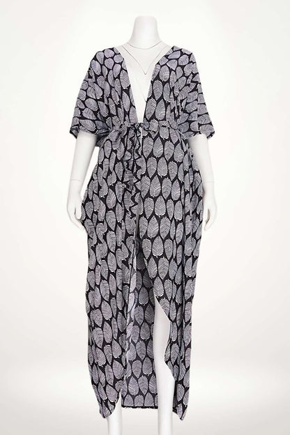 Kimono de plage léger avec un motif de feuilles blanches sur fond noir, offrant élégance et fluidité