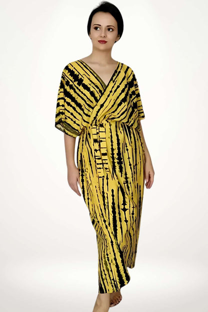 Kimono de plage jaune à motifs noirs, léger et fluide, porté par une femme debout sur fond neutre