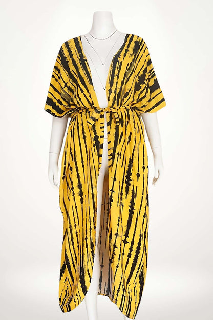 Kimono de plage aérien en tissu jaune avec motifs noirs, ouvert sur les côtés et ceinturé à la taille