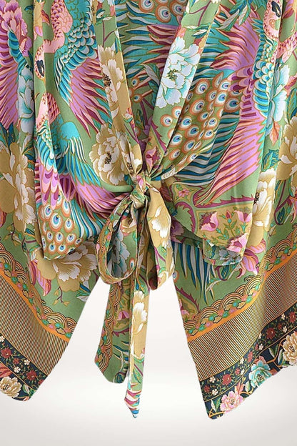 Un kimono aux motifs floraux colorés, dominé par des teintes vertes, roses et bleues, avec un nœud élégant