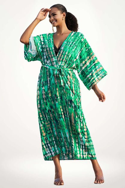 Femme souriante en kimono vert à motifs, posant avec une main sur le front, décor lumineux et ensoleillé