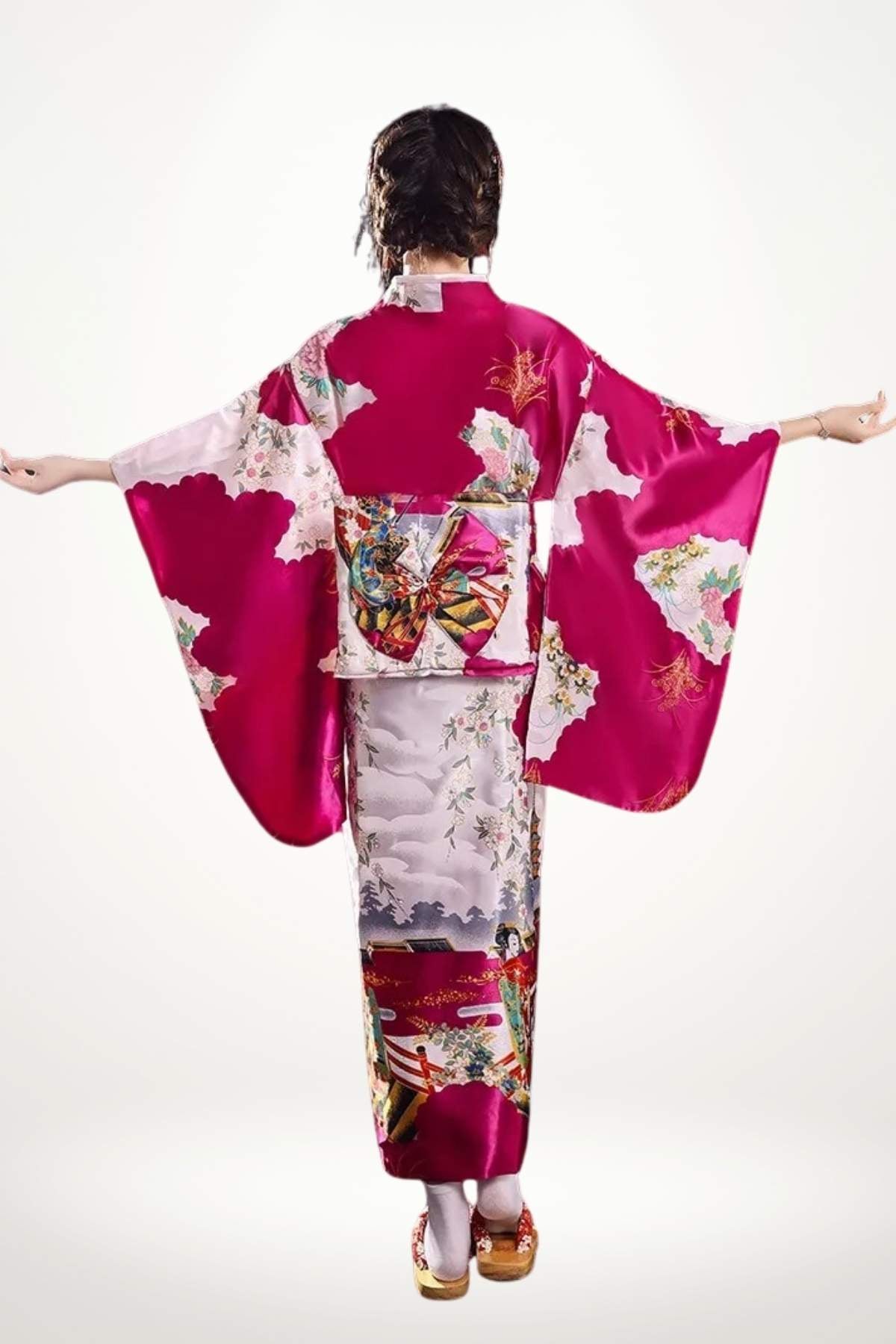 Femme portant un kimono en satin rose avec motifs floraux, bras écartés, fond blanc lumineux
