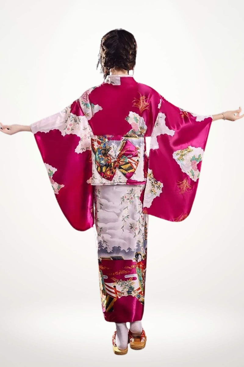 Femme portant un kimono en satin rose avec motifs floraux, bras écartés, fond blanc lumineux