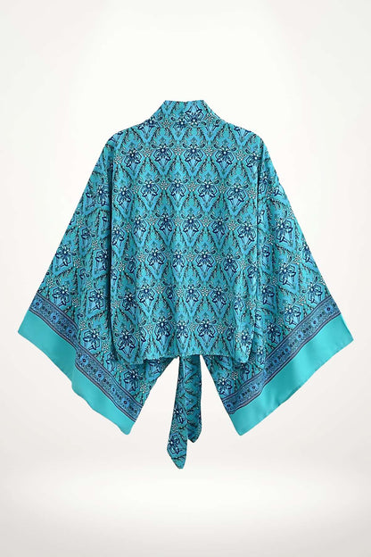 Kimono en satin turquoise avec un motif géométrique bleu et des manches larges, noué à l'arrière