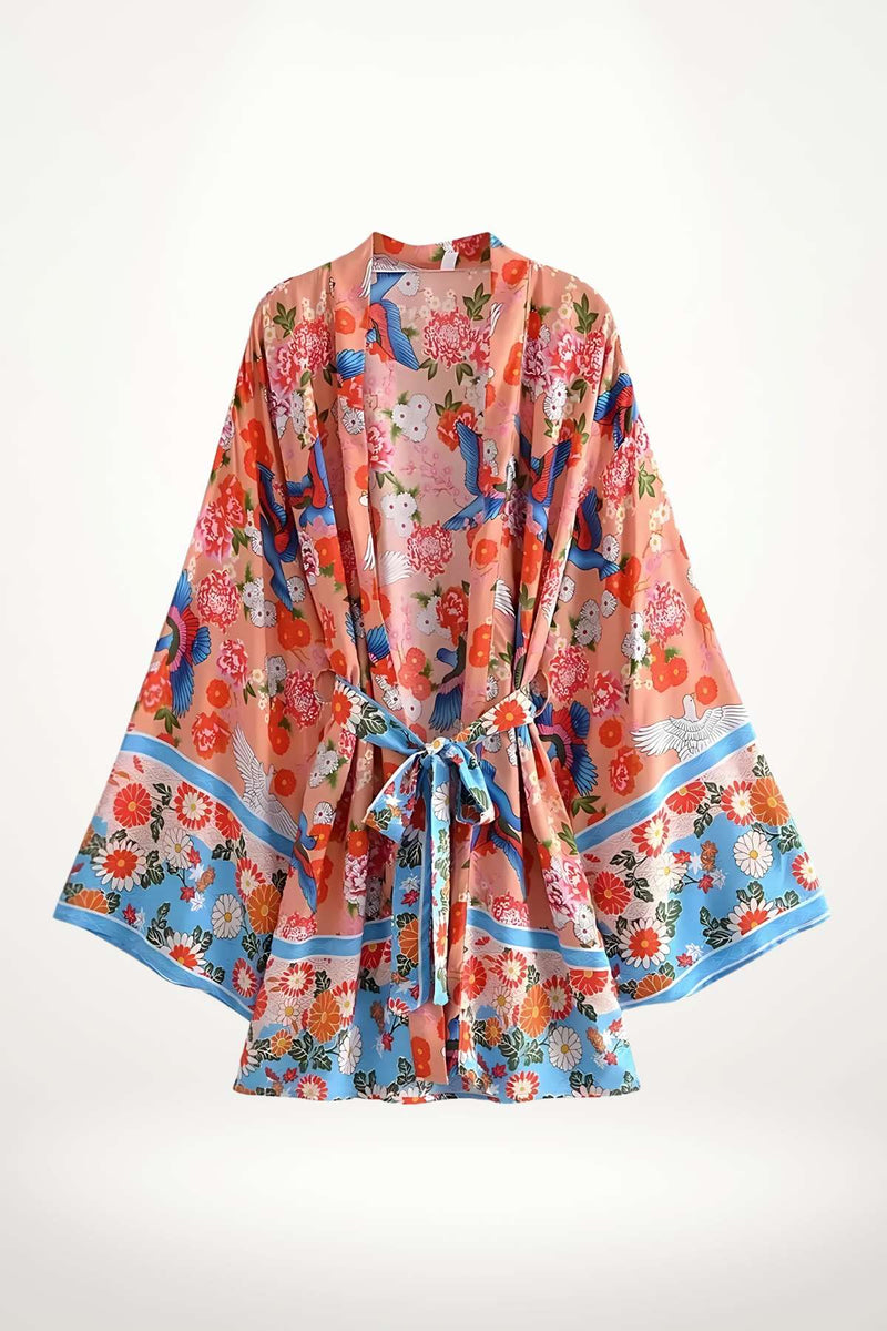 Kimono léger aux motifs floraux colorés, avec des oiseaux, dans des tons de rose et bleu, évoquant l'été