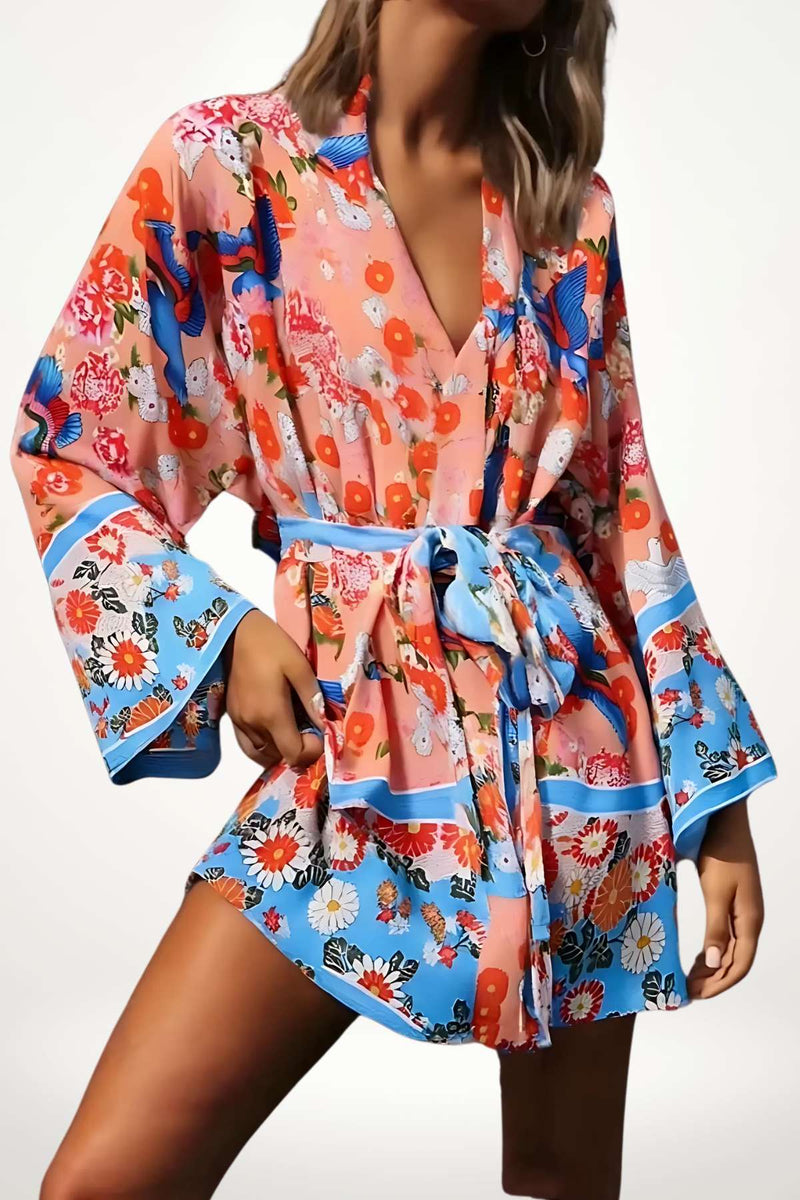 Kimono léger aux motifs floraux colorés, avec des manches évasées et une ceinture, sous un fond clair