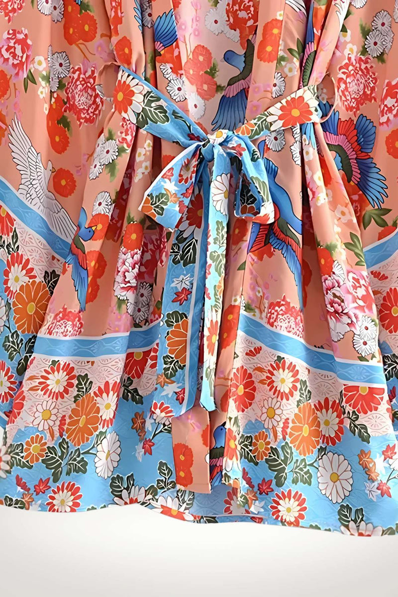 Kimono léger aux motifs floraux colorés, dominé par des teintes roses et bleues, avec un nœud à la taille