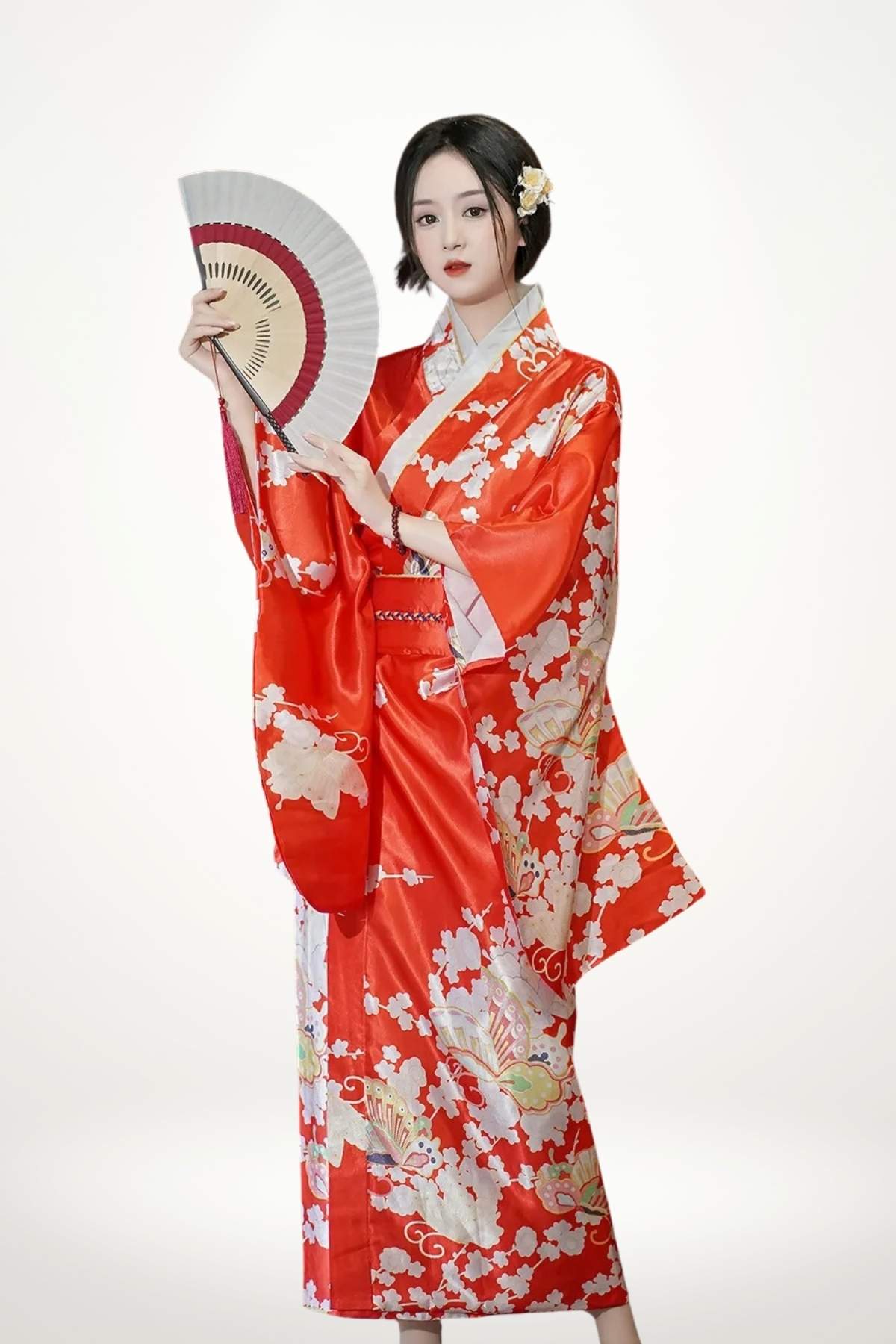 Femme portant un kimono long rouge en satin à motifs geishas, éventails et cerisiers, ceinture obi tressée.

