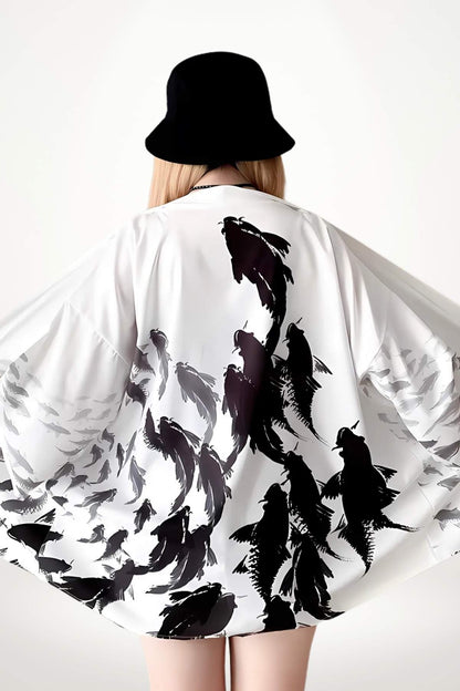 Femme de dos portant un kimono blanc avec un motif noir de poissons, sous un chapeau noir
