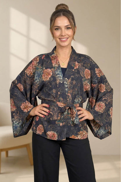 Femme souriante portant un kimono noir à motifs floraux dans un décor intérieur lumineux et moderne
