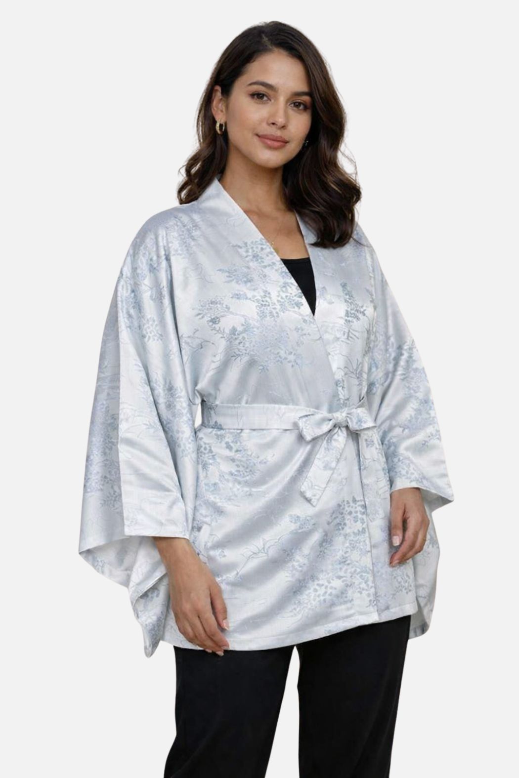 Femme portant un kimono en satin argenté avec des motifs floraux, dans une posture élégante et décontractée