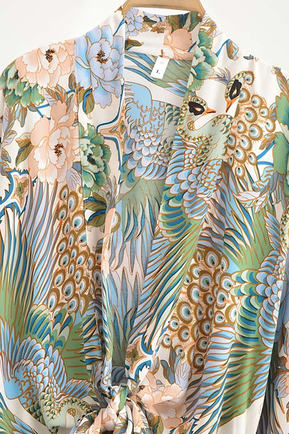 Kimono court en tissu léger avec motifs floraux et plumes dans des tons pastel de bleu et rose