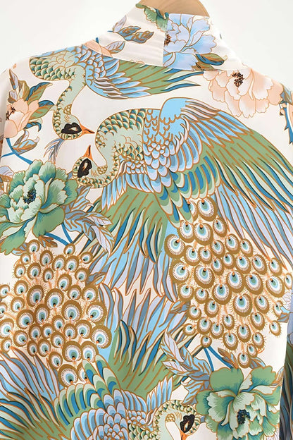 Imprimé floral en vert et bleu avec des motifs de grues et de paons sur un fond crème