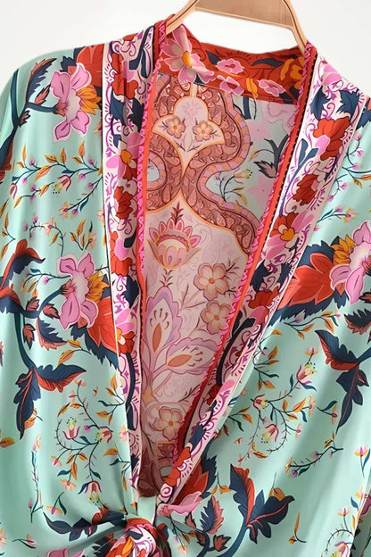 Kimono court en tissu léger avec motifs floraux colorés sur fond vert et détails roses vifs