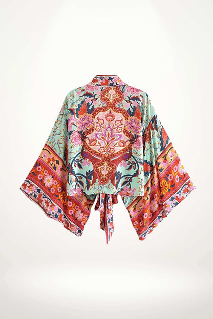 Kimono court en satin avec motifs floraux colorés sur fond bleu et rouge, manches larges et ceinture nouée