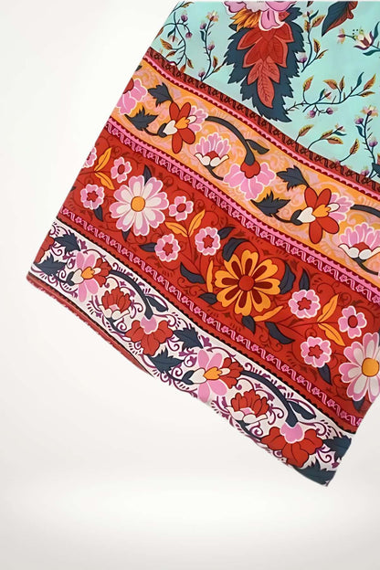 Un kimono court avec des motifs floraux colorés sur un fond bleu et rouge, évoquant un style japonais vibrant