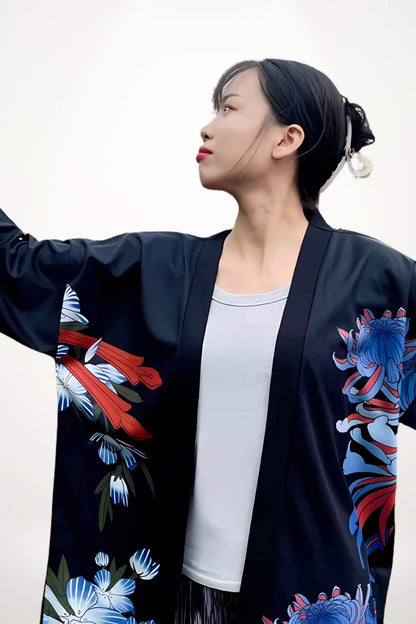 Femme portant un kimono noir avec des motifs floraux colorés, regardant vers le haut dans un décor minimaliste