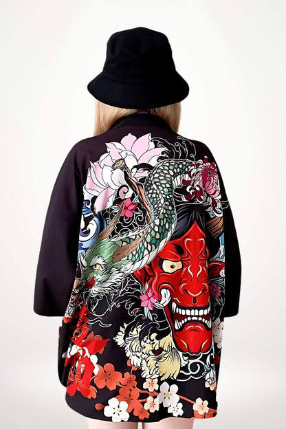 Femme portant un kimono noir aux motifs colorés de dragon et de fleurs, avec un chapeau noir