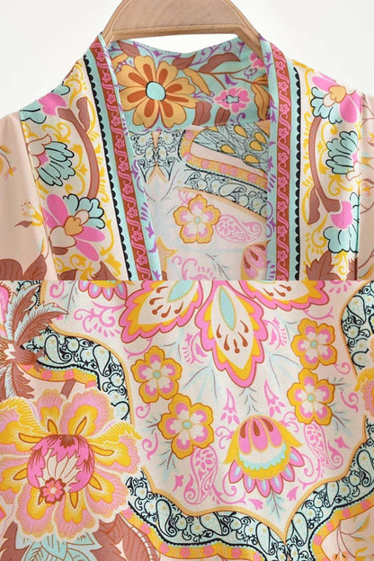Kimono court aux motifs floraux colorés avec des tons de rose, bleu et jaune, parfait pour l'été