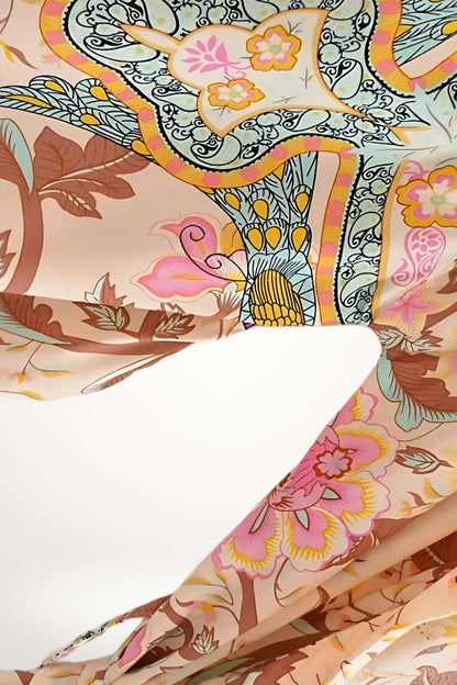 Un kimono court aux motifs floraux colorés sur fond rose, parfait pour un style estival et léger