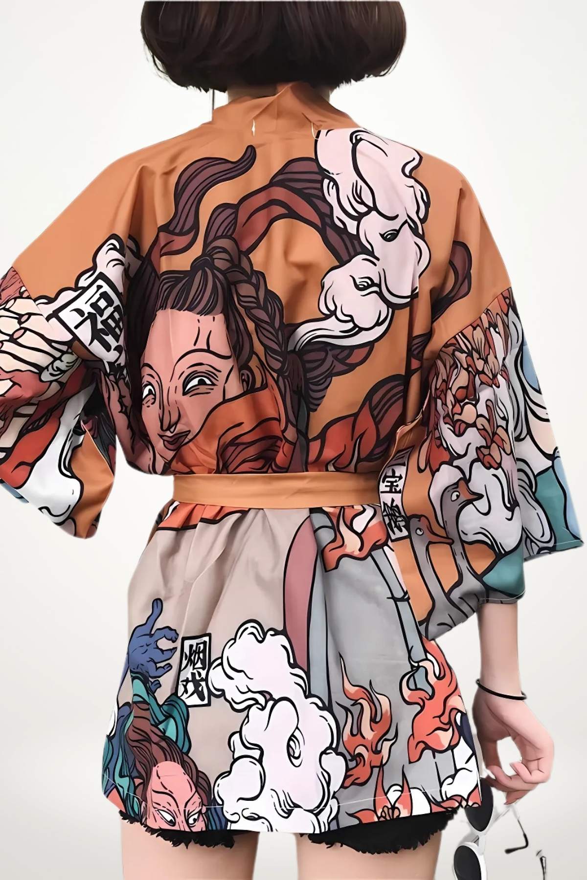 Kimono court en tissu coloré avec motifs japonais, affichant des visages et des nuages, porté avec une ceinture