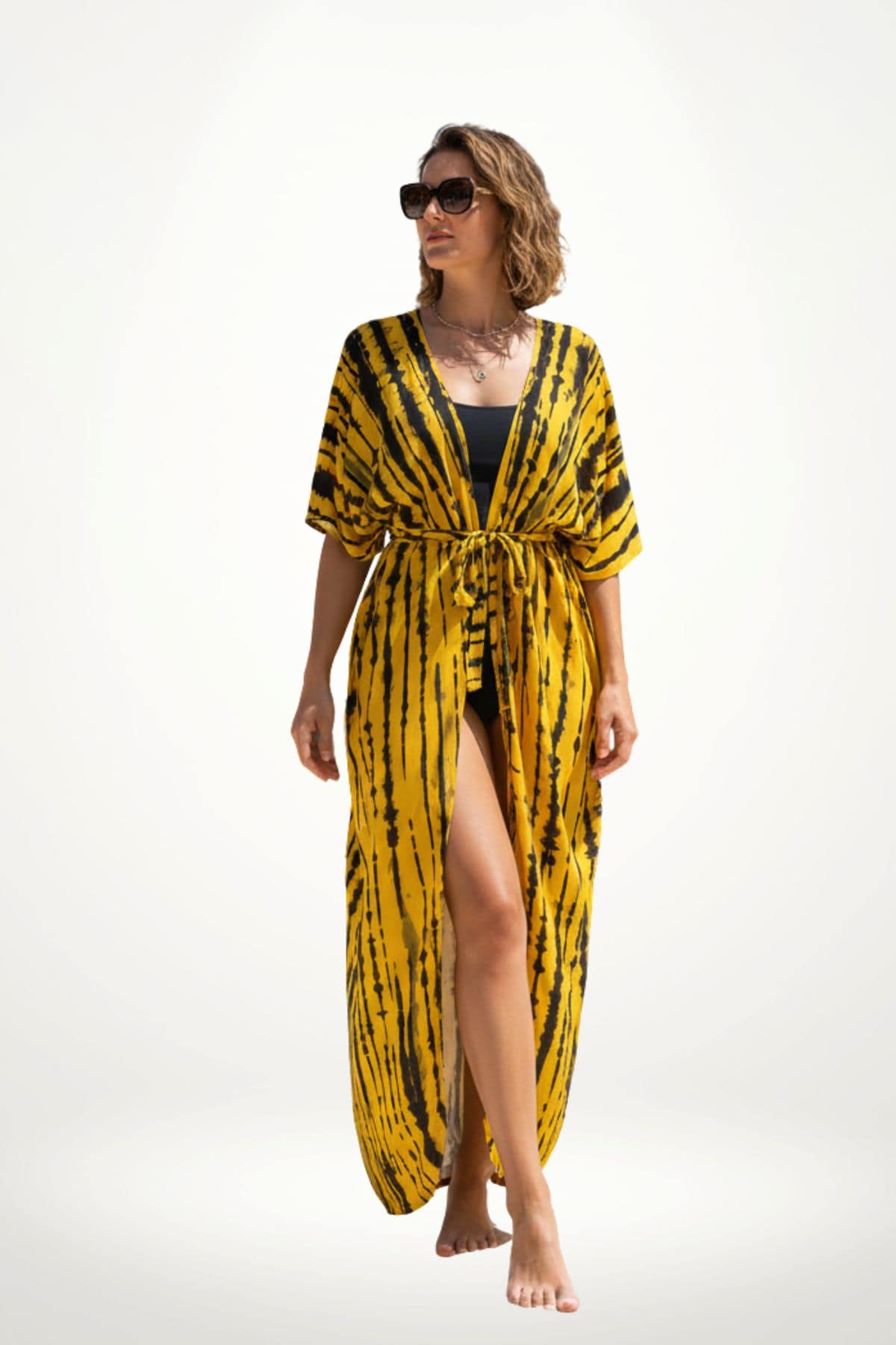 Femme en kimono jaune à motifs noirs, debout sur un fond clair, portant des lunettes de soleil et un maillot