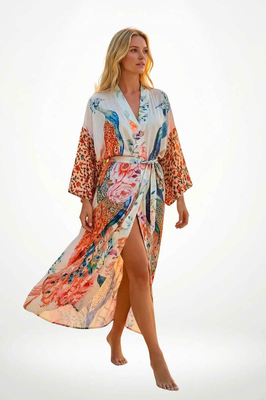 Femme en kimono satin aux motifs floraux et animaliers, marchant pieds nus sur un fond lumineux