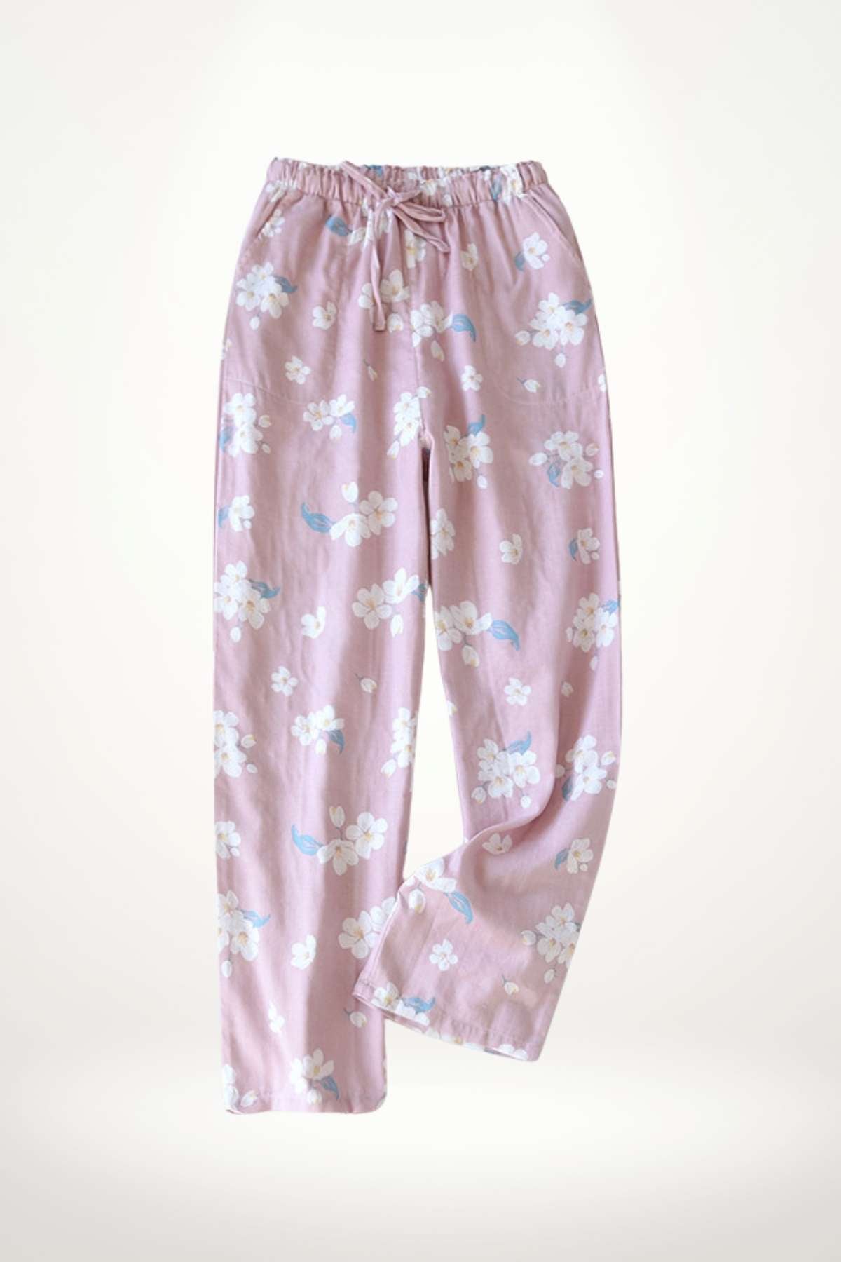 Pantalon en coton rose clair orné de motifs floraux blancs et bleus, avec une taille élastique ajustable
