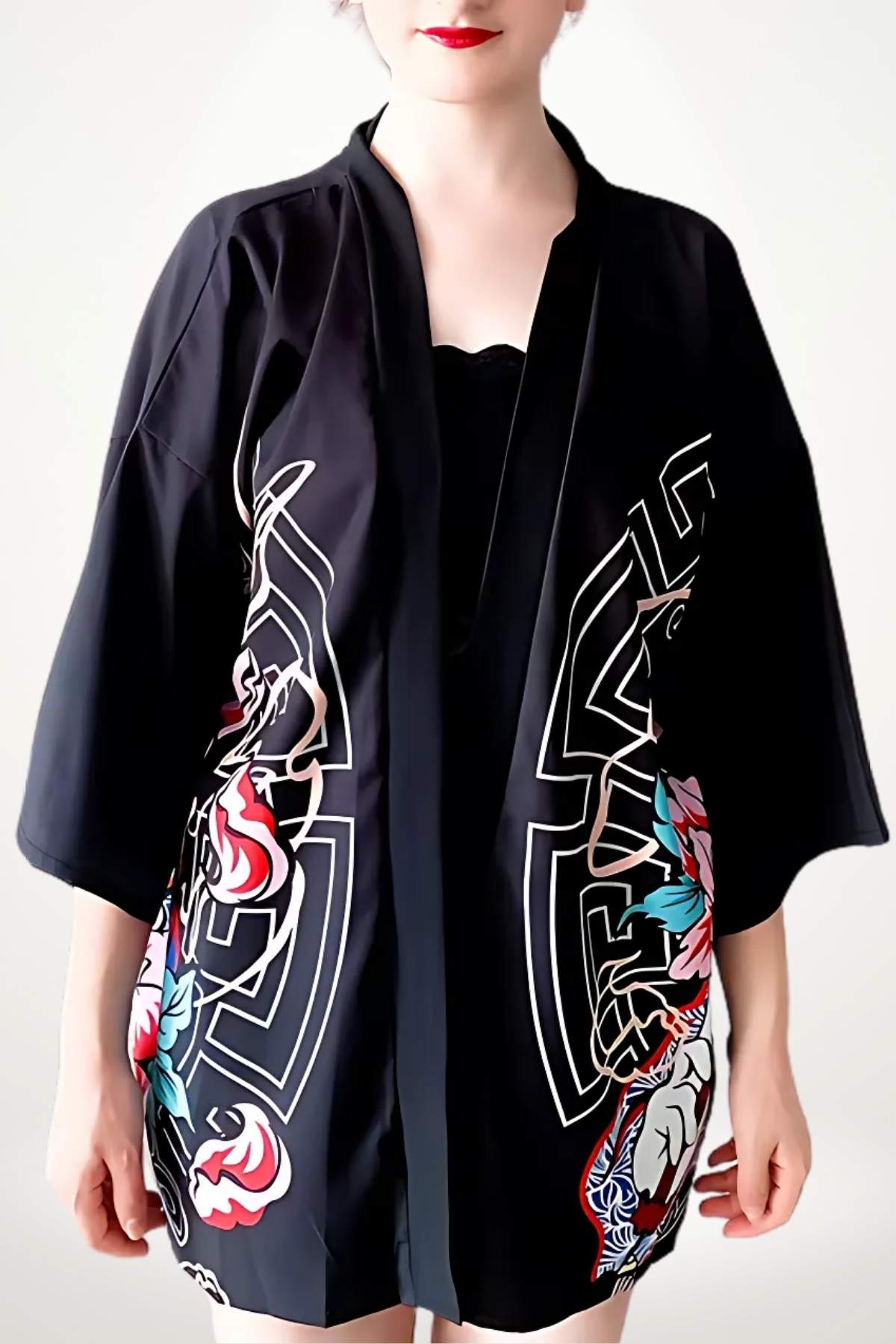 Kimono noir à motifs floraux colorés, porté avec une posture décontractée sur fond blanc