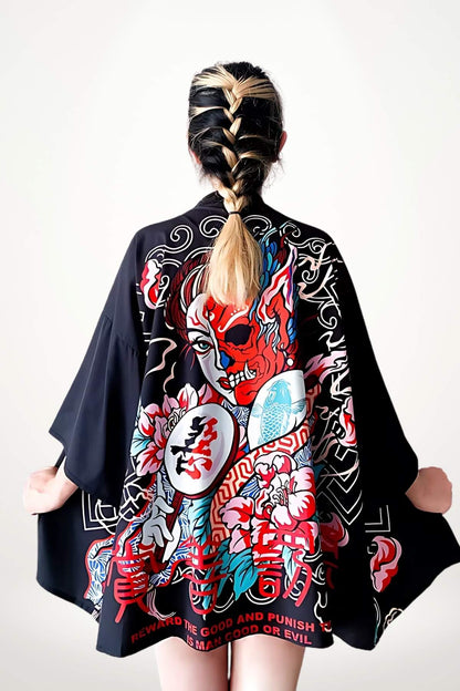 Femme de dos portant un kimono noir orné de motifs colorés, avec des fleurs et un visage stylisé, sur fond