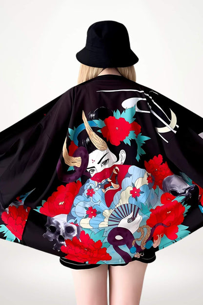 Kimono noir à motifs floraux rouges et bleus, porté par une femme avec un chapeau, dans un décor minimaliste
