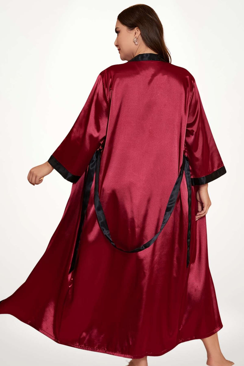 Kimono élégant en satin rouge avec des détails noirs, porté par une femme, dans une posture gracieuse