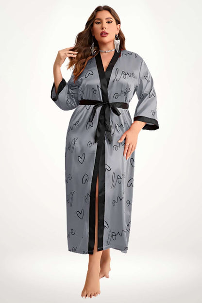 Femme en kimono gris avec motifs de cœurs noirs, ceinture noire, posture élégante, fond clair