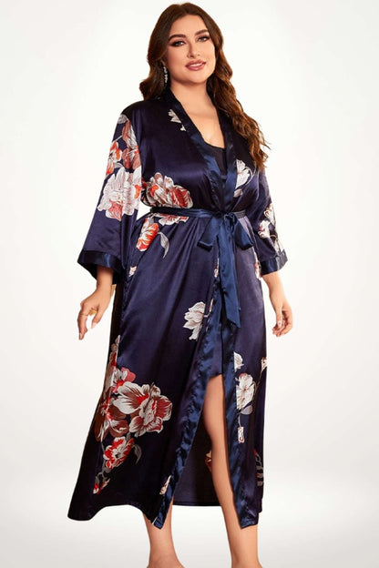 Kimono long en satin bleu marine avec motifs floraux, ceinture nouée et manches larges, mettant en valeur la légèreté