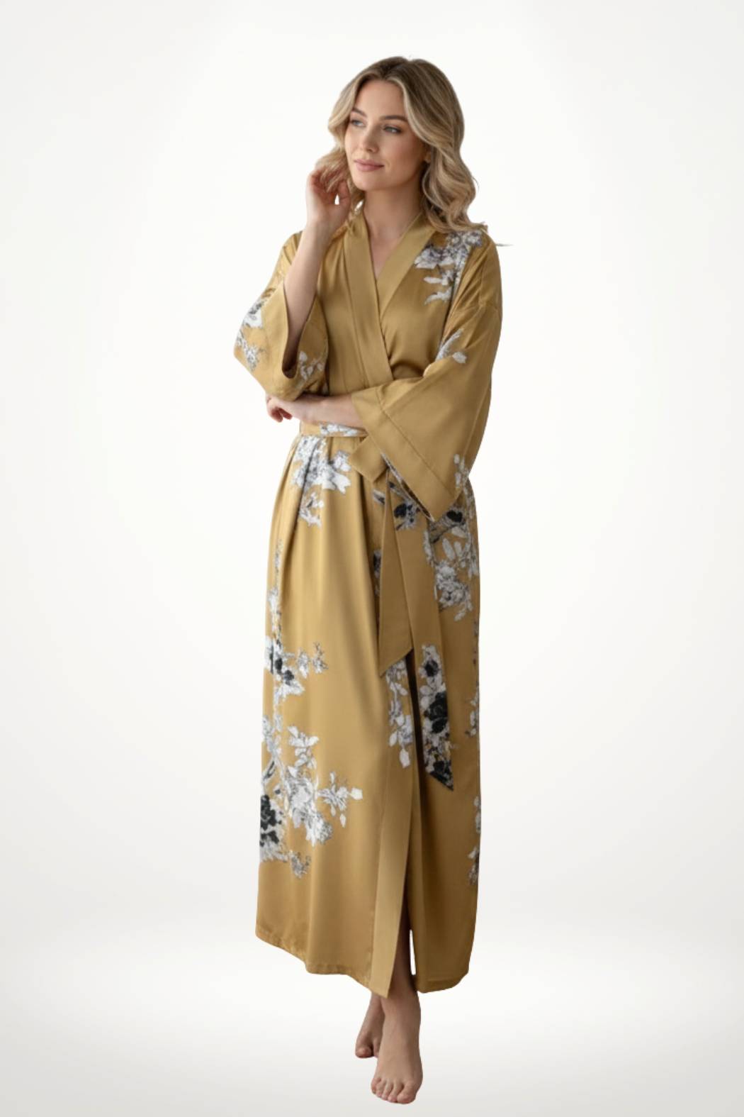 Femme en kimono satin doré avec motifs floraux, debout, souriante, dans un décor minimaliste et lumineux