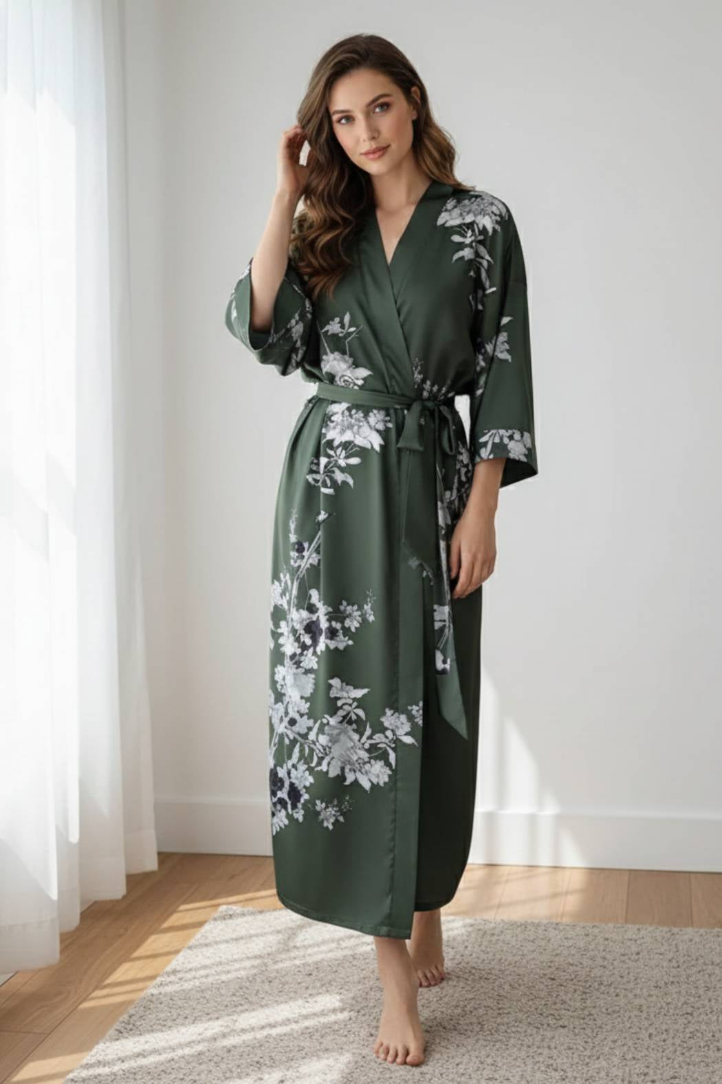 Femme en kimono vert foncé avec motifs floraux, posant dans un intérieur lumineux et moderne