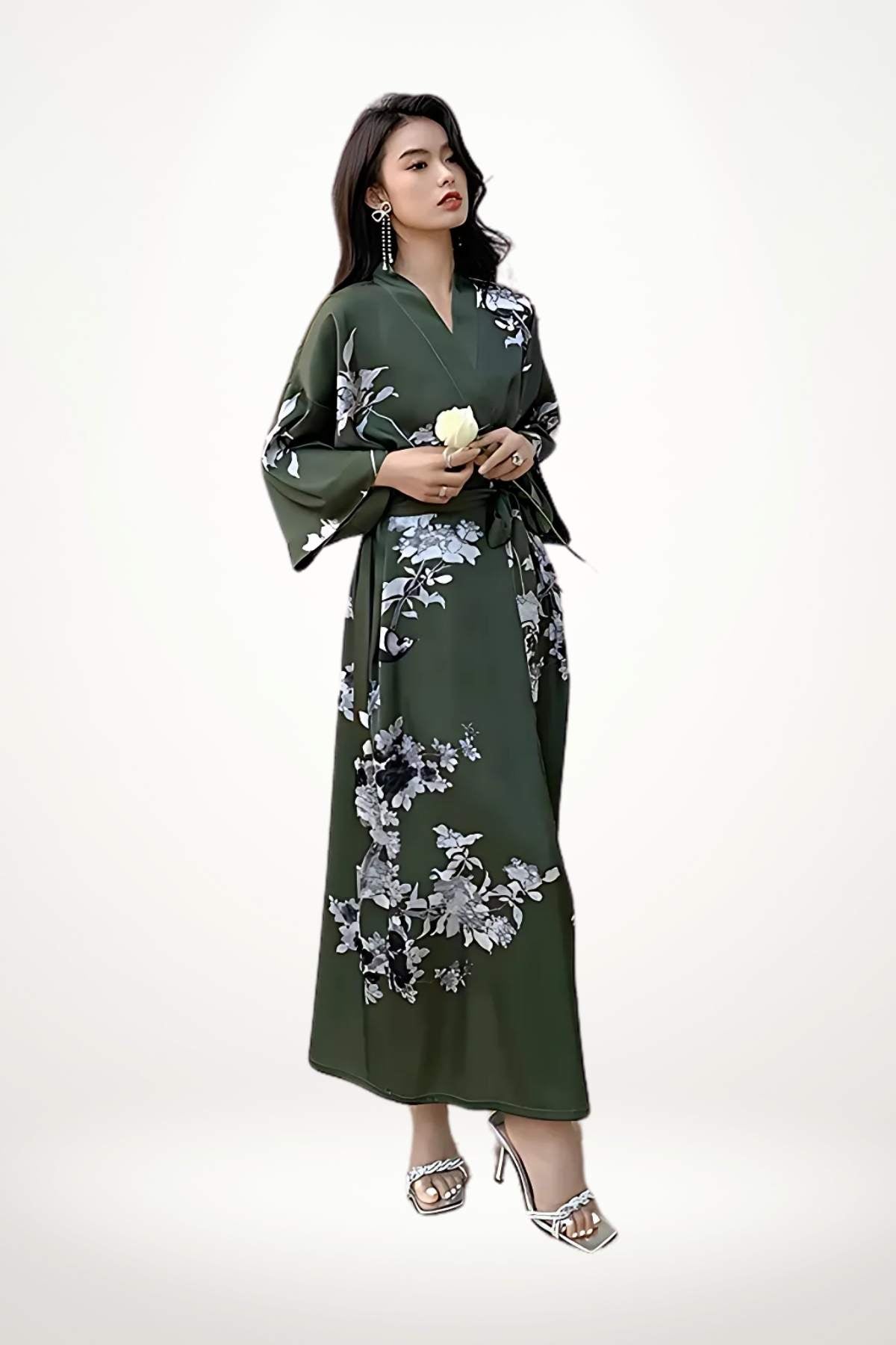 Femme en kimono vert foncé avec motifs floraux, posant élégamment avec une rose blanche dans les mains