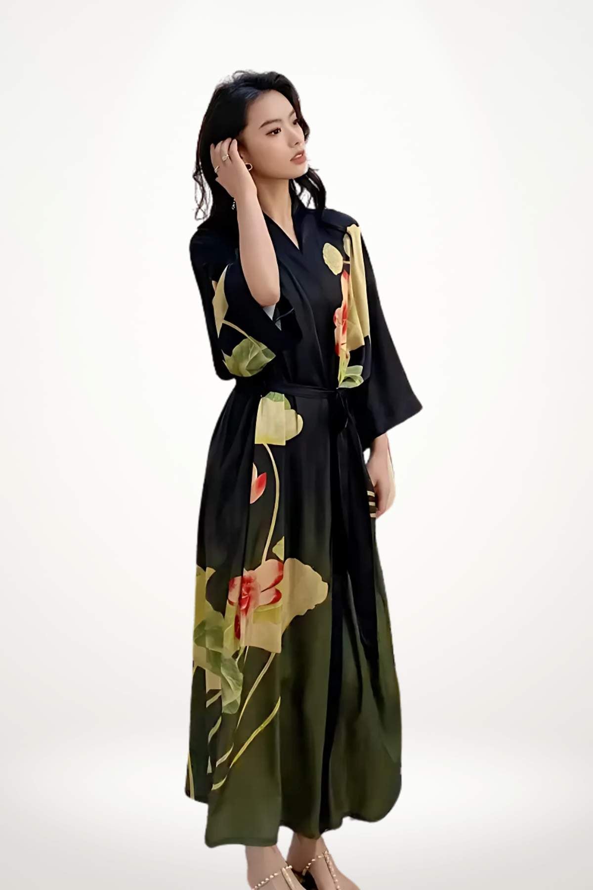 Femme en kimono noir avec motifs floraux, posant élégamment sur fond neutre, cheveux lâchés et main sur la tête