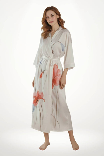Femme portant un kimono blanc avec des motifs floraux colorés, posé sur un fond neutre et lumineux