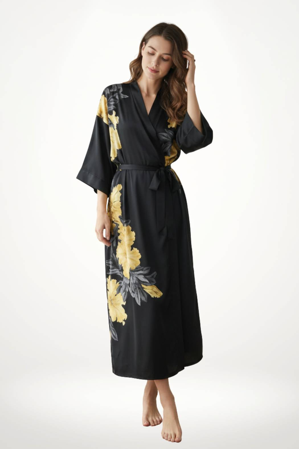 Femme en kimono noir avec motifs floraux jaunes, posant légèrement, décor minimaliste en arrière-plan