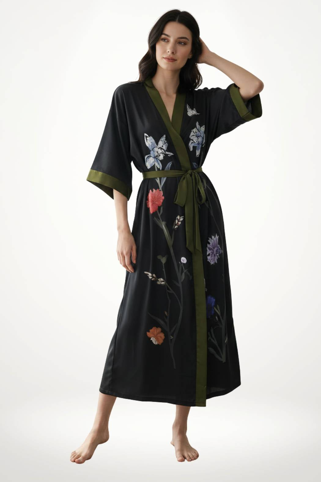 Femme portant un kimono noir élégant avec des motifs floraux colorés et une ceinture verte, sur fond neutre