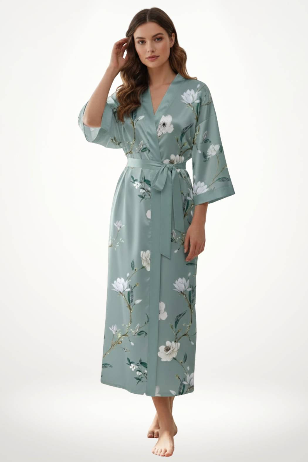 Femme en kimono léger vert avec motifs floraux, posant avec une main dans les cheveux sur fond neutre