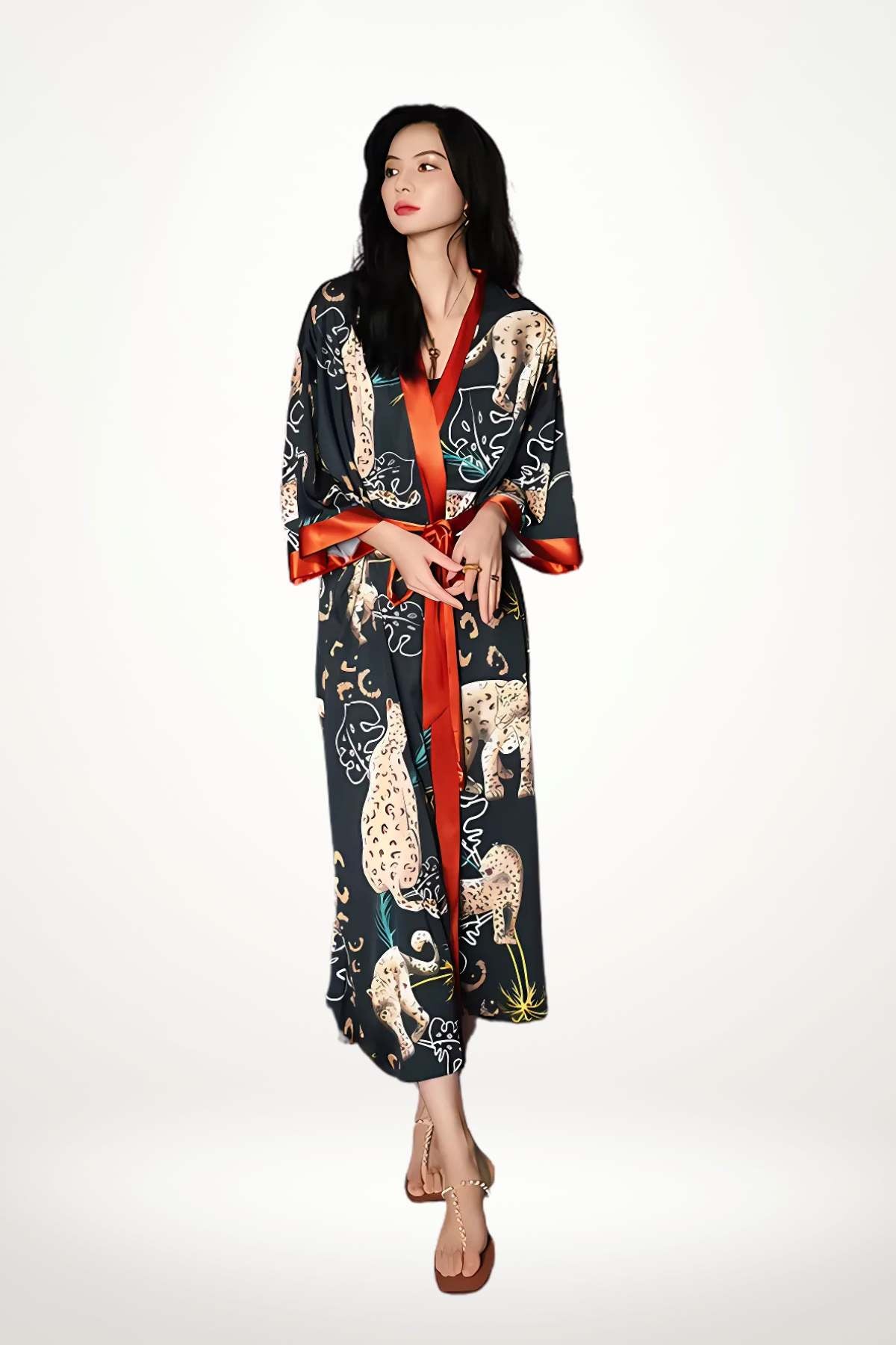 Femme en kimono noir avec motifs félins, ceinture rouge, posant sur fond clair avec une allure audacieuse